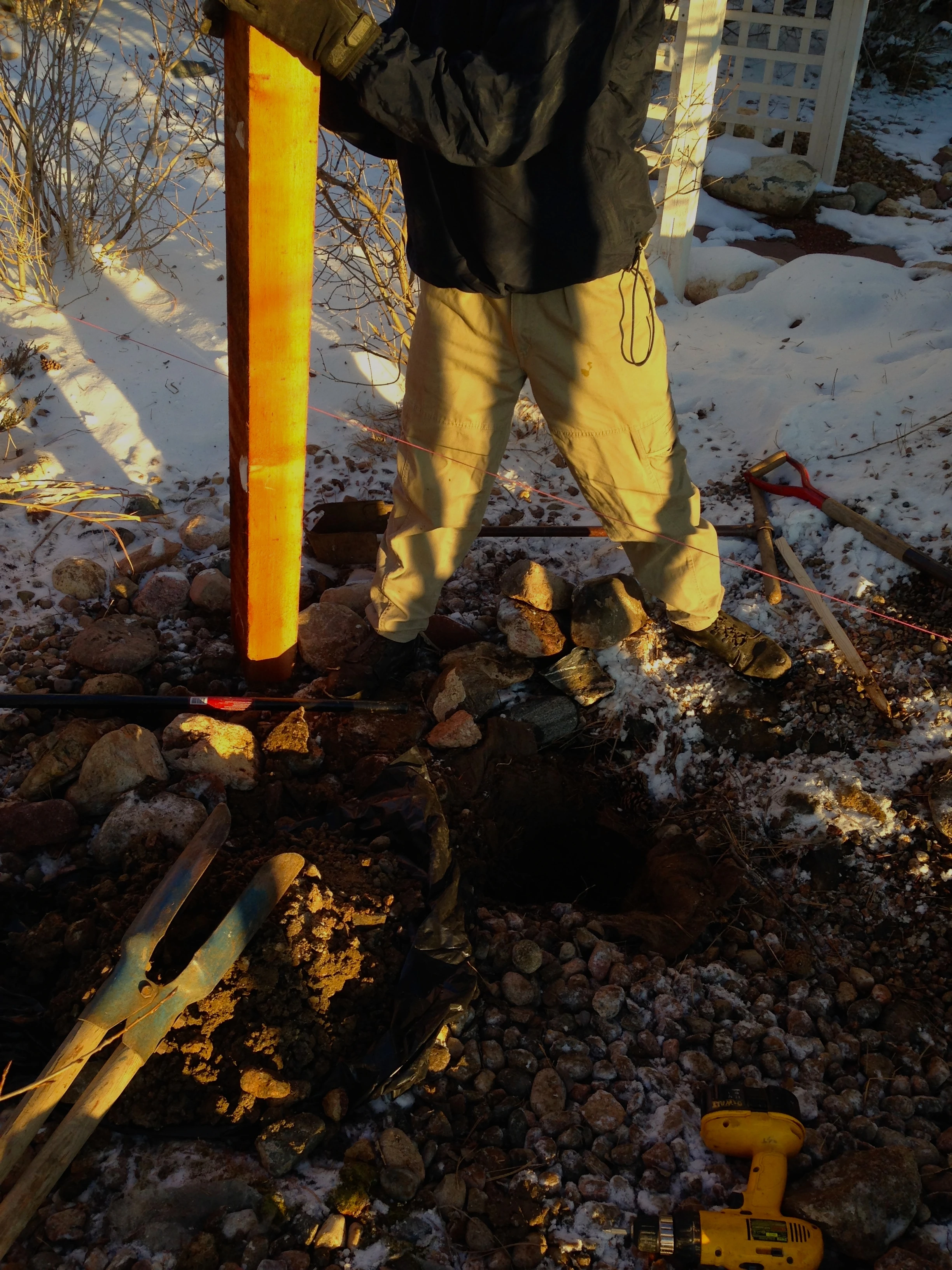 Bill looking at his pile of rocks from his hole.