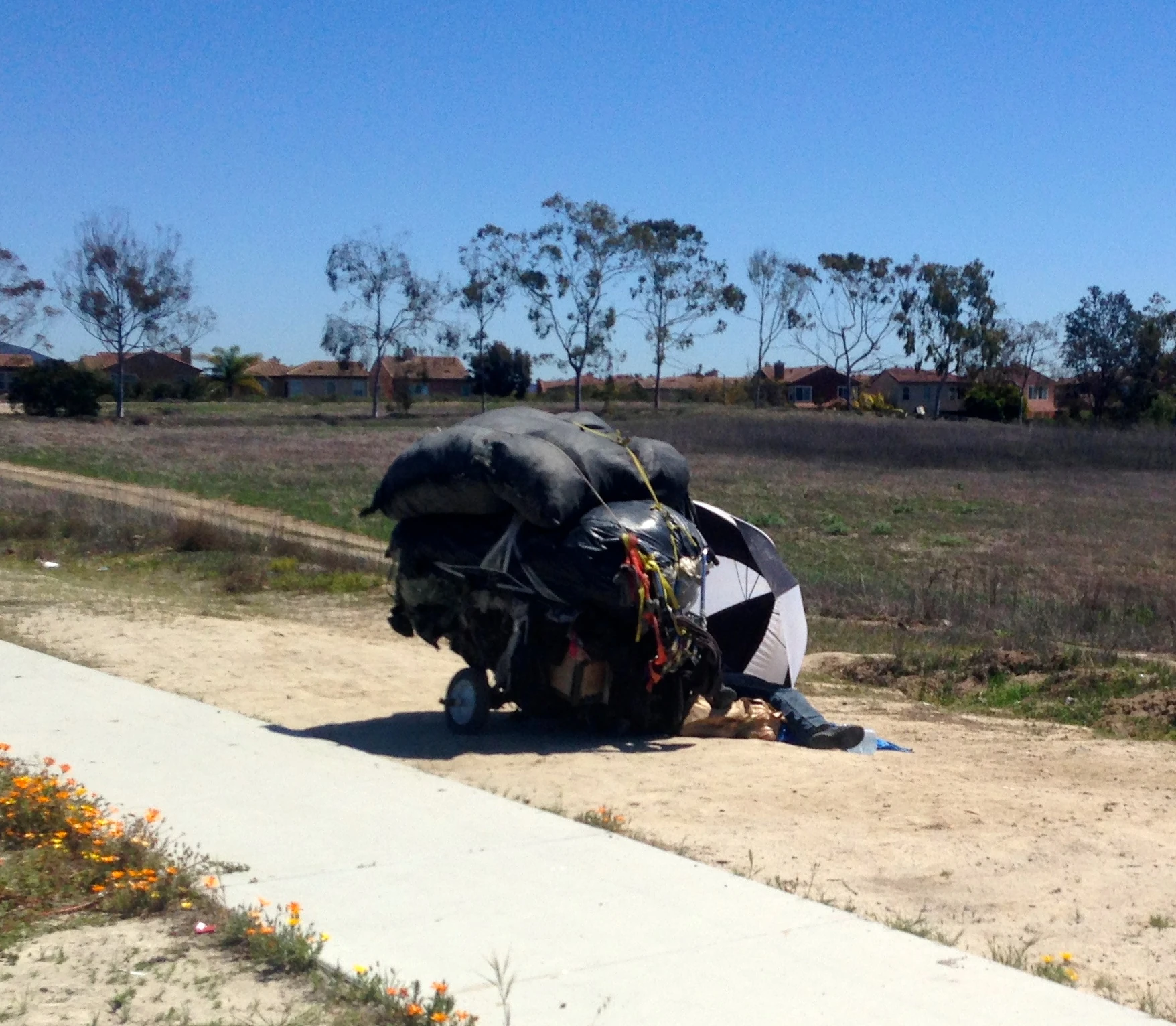 Many of the homeless guys around here have quite a load of stuff. This guy was sleeping out under his shopping cart at noon.