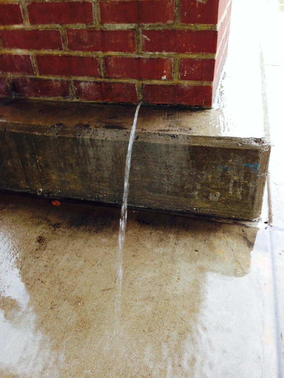 Water was pouring out of a pillar at a local shopping mall. I have no idea what the problem is to have this brick column full of water, but something is really wrong.
