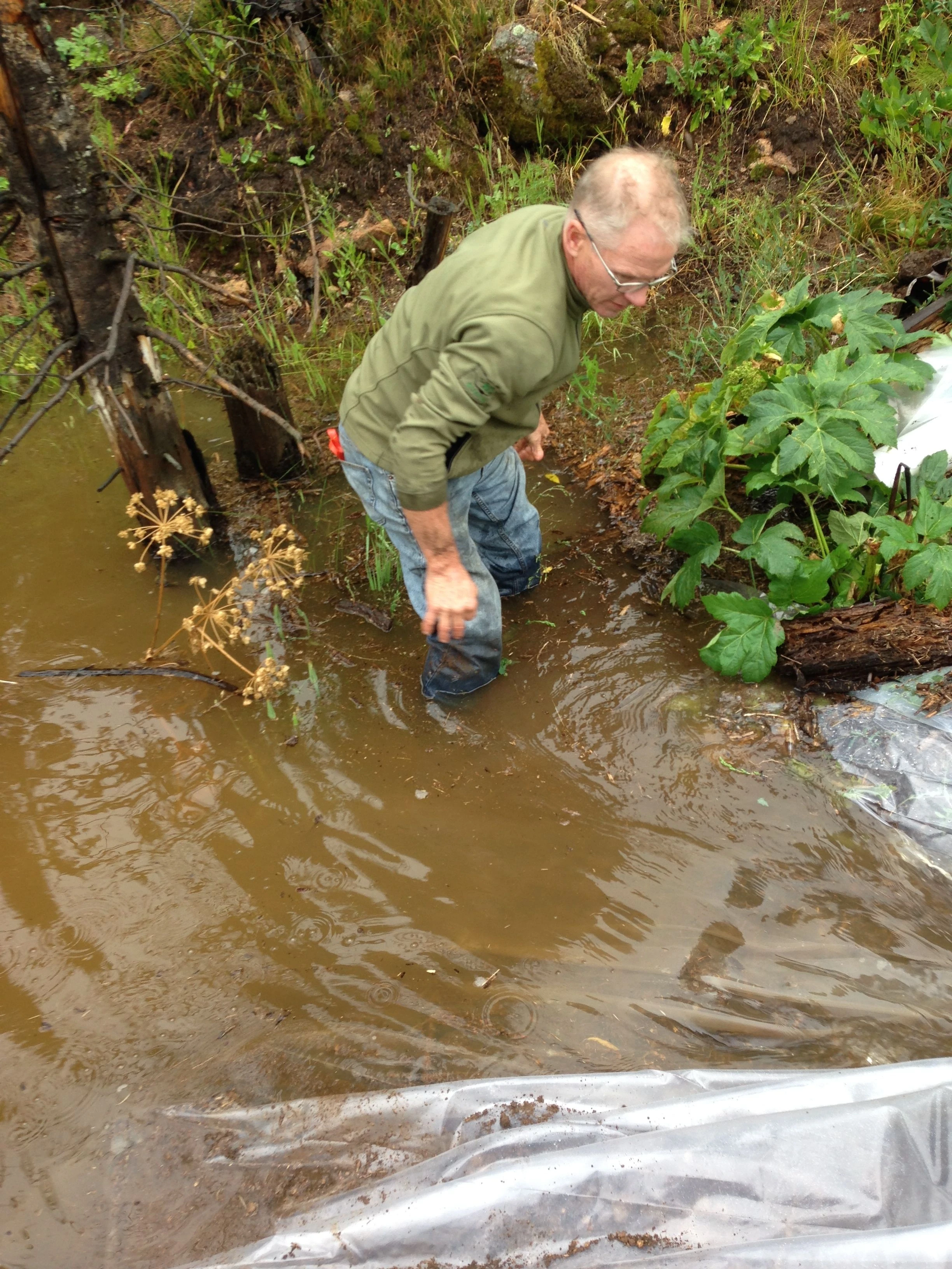 Kent doing a temporary fix, lining our spillway with plastic.