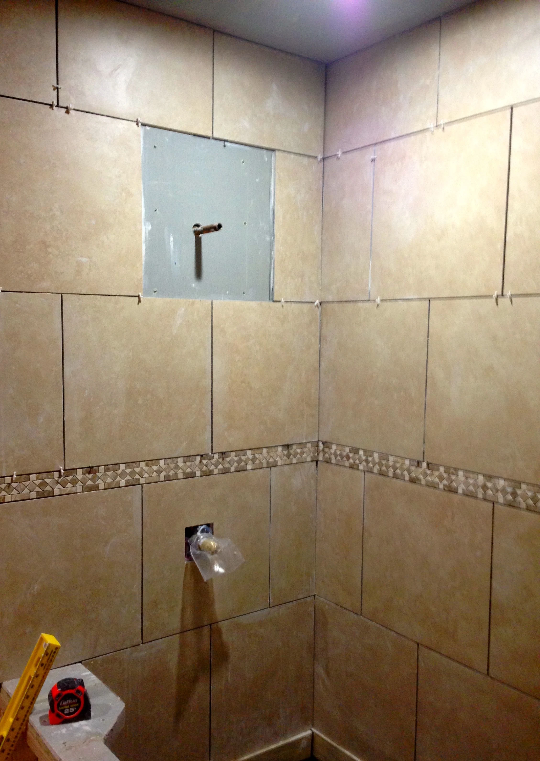 I didn&rsquo;t have a saw to cut the hole for the shower head pipe, so I just tiled around it. Don&rsquo;t worry, I measured pretty carefully to make sure it was the right size and square.