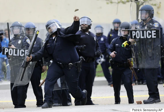 A police officer throws an object at protestors. (AP Photo/Patrick Semansky)