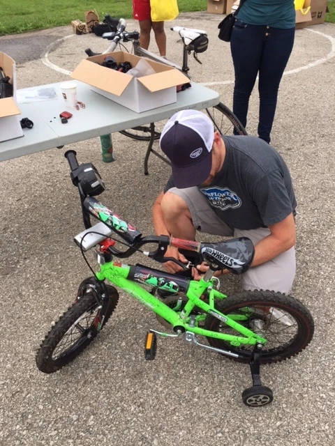 Dan Hughes, owner of Sunflower Bike shop, mounting some lights on one of the kid&rsquo;s bikes.
