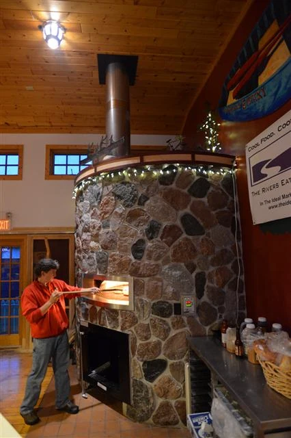 Mick putting a pizza in.